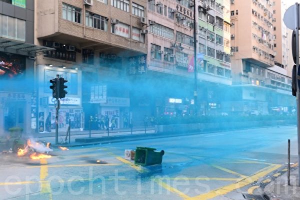 Cảnh sát phun nước màu xanh vào người biểu tình. 